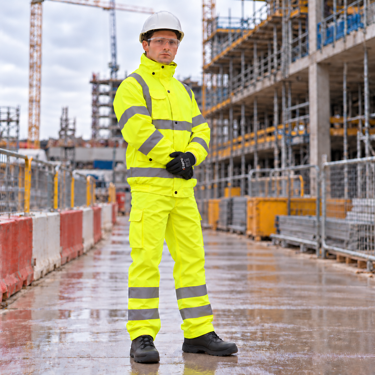 Construction worker in an Espro yellow hi-vis bomber jacket and trousers on a building site